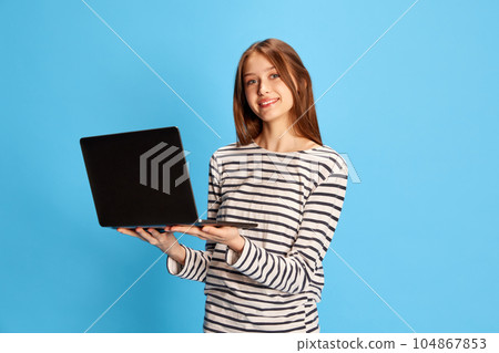 Job fair. Young pretty girl standing with laptop and smiling against blue studio background. Employment Job fair. Young pretty girl standing with laptop and smiling against blue studio background. Employment 104867853
