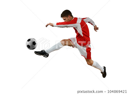 Soccer player kicks the soccerball in the air by jumping 104869421
