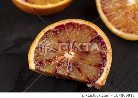 the red-orange flesh of an orange sliced in close-up the red-orange flesh of an orange sliced in close-up 104869912