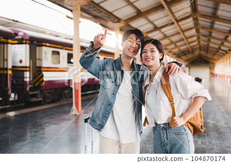 Asian couple at railway station have happy moment. Tourism and travel in the summer Asian couple at railway station have happy moment. Tourism and travel in the summer 104870174