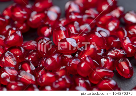 Grains of red ripe pomegranate close up Grains of red ripe pomegranate close up 104870373