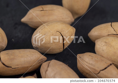cracked unpeeled pecans close-up on the table cracked unpeeled pecans close-up on the table 104870374