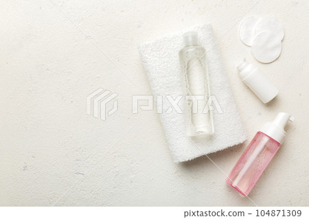 Micellar cleansing water and discs to remove cosmetics and cleanse the skin on colored background. Copy space top view 104871309