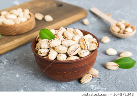 Fresh healthy Pistachios in bowl on colored table background. Top view Healthy eating concept. Super foods Fresh healthy Pistachios in bowl on colored table background. Top view Healthy eating concept. Super foods 104871348
