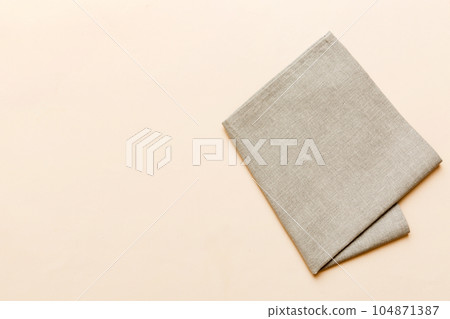 top view with gray kitchen napkin isolated on table background. Folded cloth for mockup with copy space, Flat lay. Minimal style top view with gray kitchen napkin isolated on table background. Folded cloth for mockup with copy space, Flat lay. Minimal style 104871387