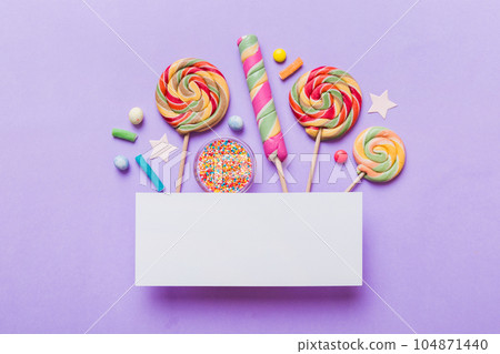 Flat lay holiday composition. Paper blank, lollipop, birthday decorations on Colored background. Top view, copy space for text Flat lay holiday composition. Paper blank, lollipop, birthday decorations on Colored background. Top view, copy space for text 104871440