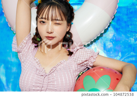 穿著泳衣放鬆的年輕女子 穿著泳衣放鬆的年輕女子 104872538