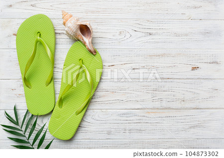 Flat lay composition with flip flops and seashell on colored background. Space for text top view 104873302