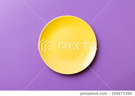 Top view of isolated of colored background empty round yellow plate for food. Empty dish with space for your design 104873360