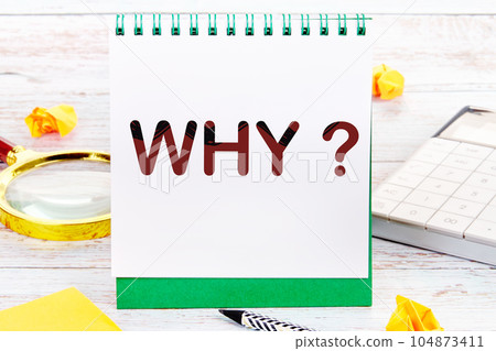 Why Text on a sheet of notepad standing on the table next to a magnifying glass, calculator, stickers Why Text on a sheet of notepad standing on the table next to a magnifying glass, calculator, stickers 104873411