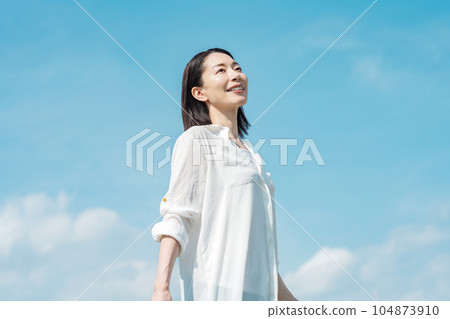 Blue sky portrait of a middle-aged woman Blue sky portrait of a middle-aged woman 104873910