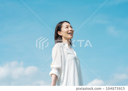 Blue sky portrait of a middle-aged woman 104873915