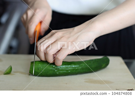 A woman cutting cucumbers in rhythm 104874808