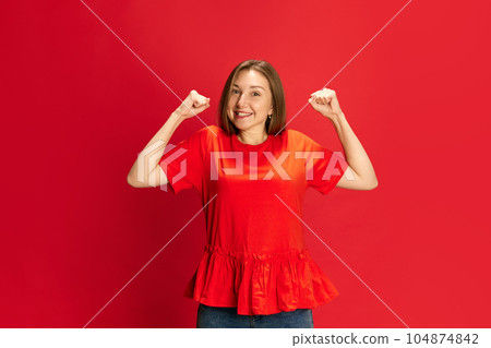 Portrait fo young beautiful woman expressing emotions of happiness, excitement and joy against red studio background. Success, win Portrait fo young beautiful woman expressing emotions of happiness, excitement and joy against red studio background. Success, win 104874842