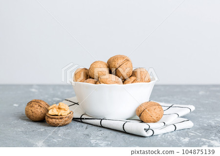 Fresh healthy walnuts in bowl on colored table background. Top view Healthy eating bertholletia concept. Super foods 104875139