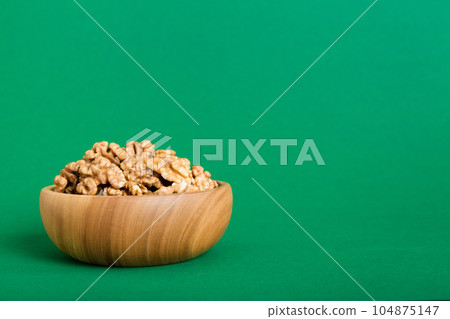 Fresh healthy walnuts in bowl on colored table background. Top view Healthy eating bertholletia concept. Super foods 104875147