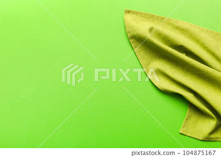 top view with green kitchen napkin isolated on table background. Folded cloth for mockup with copy space, Flat lay. Minimal style 104875167