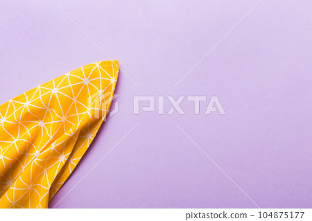 top view with yellow empty kitchen napkin isolated on table background. Folded cloth for mockup with copy space, Flat lay. Minimal style 104875177