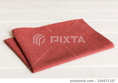 top view with red empty kitchen napkin isolated on table background. Folded cloth for mockup with copy space, Flat lay. Minimal style top view with red empty kitchen napkin isolated on table background. Folded cloth for mockup with copy space, Flat lay. Minimal style 104875187