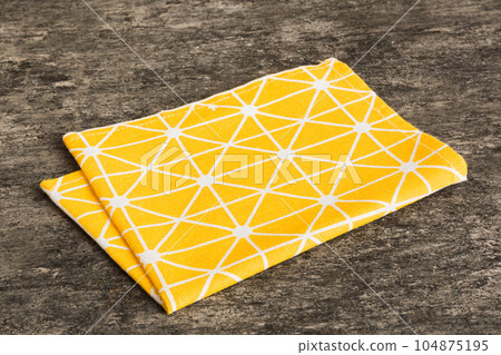 top view with yellow empty kitchen napkin isolated on table background. Folded cloth for mockup with copy space, Flat lay. Minimal style 104875195