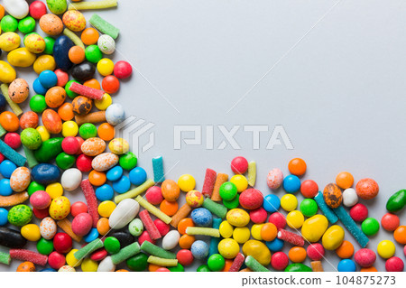Mixed collection of colorful candy, on colored background. Flat lay, top view. frame of colorful chocolate coated candy 104875273