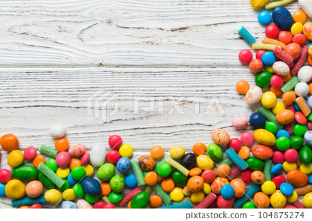 Mixed collection of colorful candy, on colored background. Flat lay, top view. frame of colorful chocolate coated candy 104875274