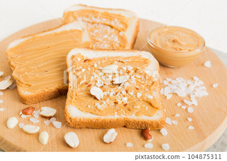 Peanut butter sandwiches or toasts on light table background.Breakfast. Vegetarian food. American cuisine top view vith copy space Peanut butter sandwiches or toasts on light table background.Breakfast. Vegetarian food. American cuisine top view vith copy space 104875311