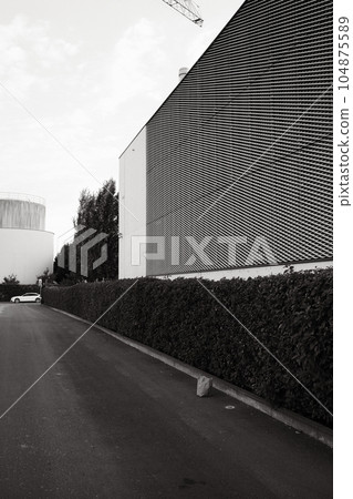 Vertical grayscale of a street with a building with a patterned exterior Vertical grayscale of a street with a building with a patterned exterior 104875589