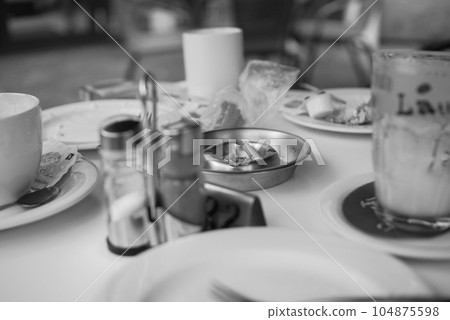 Closeup greyscale shot of salt and pepper on a table in a German bistro 104875598