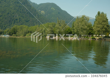 Beautiful view of a the Zeller lake at Zell am See with reflection of trees in the water, Austria 104876045