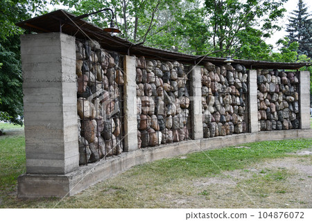 View of an art installation of stone heads behind bars in a concrete wall in Moscow, Russia 104876072
