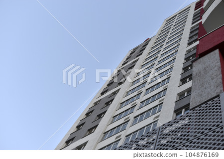 Beautiful high-rise panel residential building against the blue sky. A high-rise building in the city. A new house. Beautiful high-rise panel residential building against the blue sky. A high-rise building in the city. A new house. 104876169