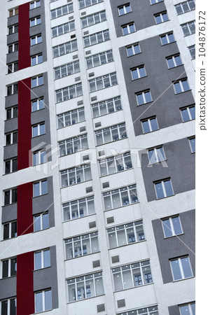 Beautiful high-rise panel residential building against the blue sky. A high-rise building in the city. A new house. 104876172