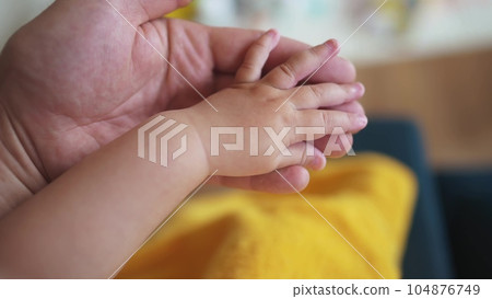 hand of a newborn baby. happy family toddler dream concept. father holding baby hand close-up. dad holding the hand of a newborn toddler. child birth lifestyle protection care concept hand of a newborn baby. happy family toddler dream concept. father holding baby hand close-up. dad holding the hand of a newborn toddler. child birth lifestyle protection care concept 104876749