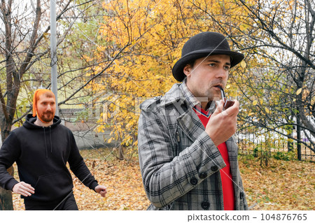 A maniac with a stocking on his head in the park is trying to attack a man from behind. 104876765
