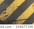 Worn weathered surface with diagonal yellow and black stripes. Nice image with dynamic elements, Color combination creates bold and striking contrast. Urban and industrial design. 104877106
