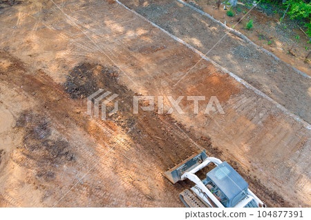Tractors equipped with tools to preparing terrain for landscaping project 104877391