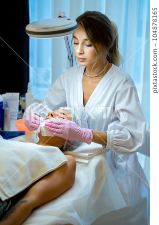 Cosmetologist doing beauty procedures or treatment to woman client in aesthetic medicine clinic 104878165