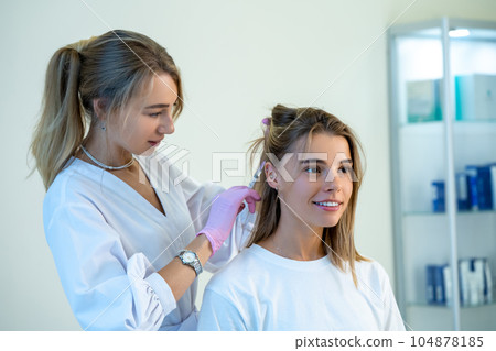 Doctor in protective medical gloves doing hair injection head rejuvenation hair loss treatment. 104878185