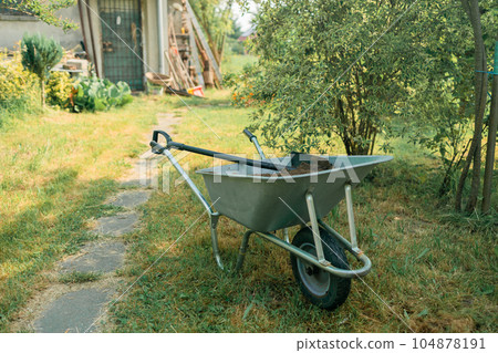 Garden cart with peat on the lawn close-up. Garden cart with peat on the lawn close-up. 104878191