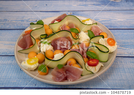 RECIPE FOR MELON, MOZARELLA, BASIL AND CURED HAM SALAD, CUCUMBER SLICE, ORANGE VINAIGRETTE RECIPE FOR MELON, MOZARELLA, BASIL AND CURED HAM SALAD, CUCUMBER SLICE, ORANGE VINAIGRETTE 104878719