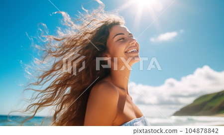 Portrait of a beautiful girl with long loose hair on the beach in front of the sea 104878842