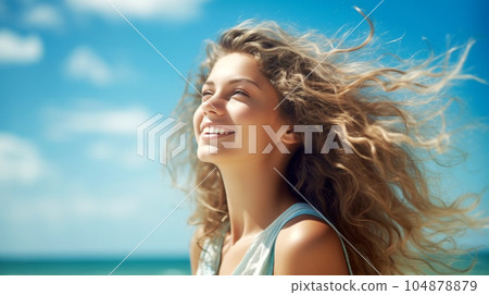 Portrait of a beautiful girl with long loose hair on the beach in front of the sea 104878879