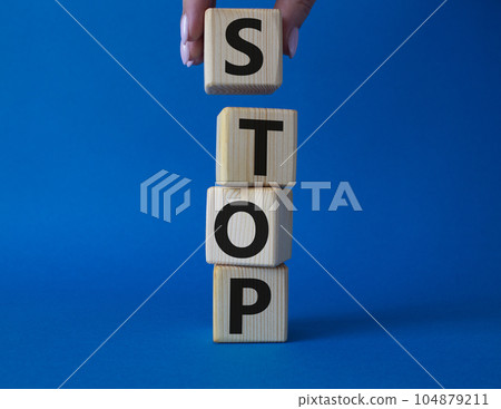 Stop symbol. Concept word Stop on wooden cubes. Businessman hand. Beautiful blue background. Business and Stop concept. Copy space. 104879211