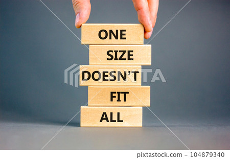 One size does not fit all symbol. Concept words One size does not fit all on wooden blocks. Businessman hand. Beautiful grey background. One size does not fit all business concept. Copy space. 104879340