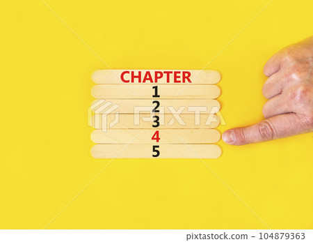 Time to chapter 4 symbol. Concept word Chapter 1 2 3 4 5 on wooden sticks. Businessman hand. Beautiful yellow table yellow background. Business planning and time to chapter 4 concept. Copy space. 104879363