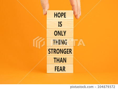 Hope stronger than fear symbol. Concept words Hope is the only thing stronger than fear on wooden blocks on a beautiful orange background. Business motivational hope stronger than fear concept. 104879372