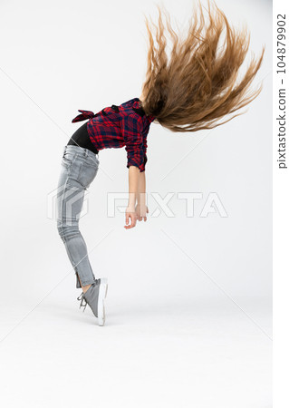 Woman forcefully throws her long hair up in the air 104879902