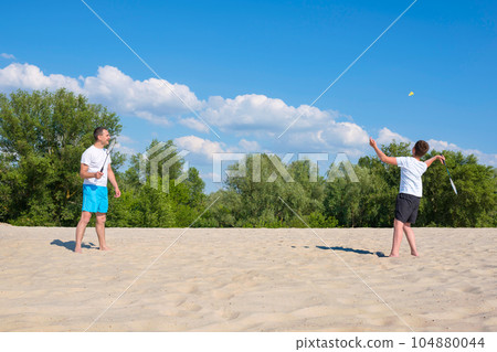 Happy family have fun on summer vacation. Sports games on the beach. 104880044