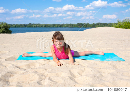 Little girl is engaged in fitness outdoors. Sport, workout, fitness, yoga Little girl is engaged in fitness outdoors. Sport, workout, fitness, yoga 104880047
